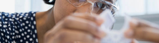 Woman scientist with safety glasses doing testing