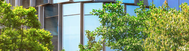 glass building  with trees in front of it