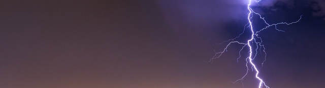 lightning striking cityscape at night 