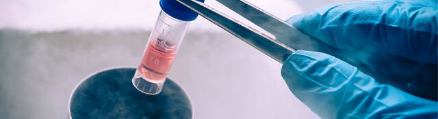Scientist taking a vial out of liquid nitrogen