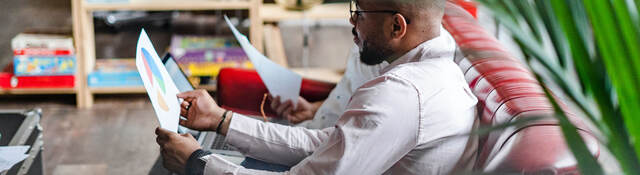 People on a couch reading business charts