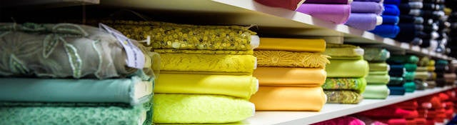 Colorful textiles folded on shelves 