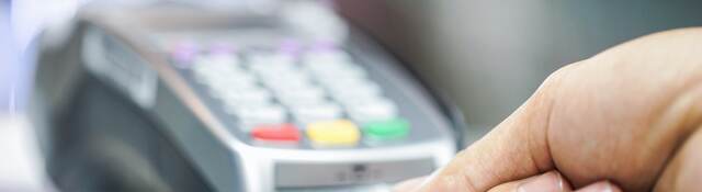 man inserting a credit card into a payment terminal