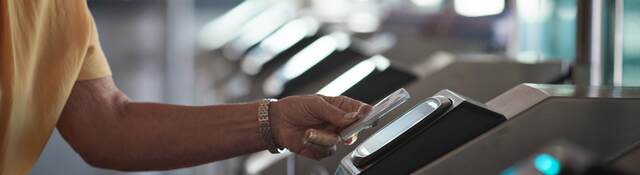 man tapping a card to open the gate