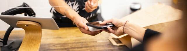 woman tapping a mobile phone to purchase