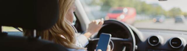 woman looking at a mobile phone in car