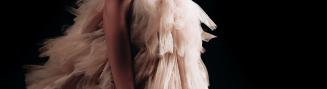 Runway fashion show with a woman in a lush beige dress
