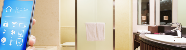 A hand holds a smartphone while in a modern bathroom
