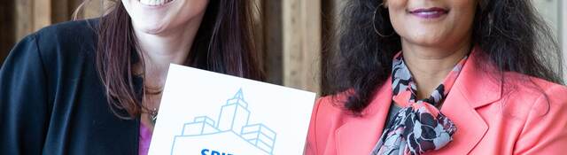 Two women from UL and MRP Realty hold up SPIRE plaque. 