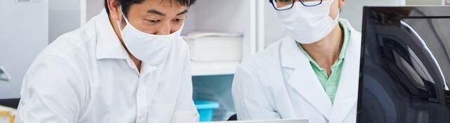 Life science researchers examining data on a laptop computer. 