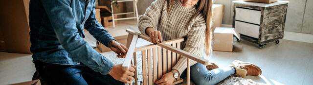 Young couple assembling furniture for new home
