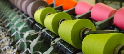 Textile industry - yarn spools on spinning machine in a textile factory