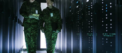 Two military men walking in data center corridor