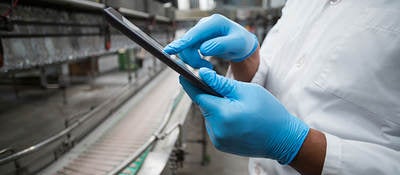 A worker checks a tablet computer.  