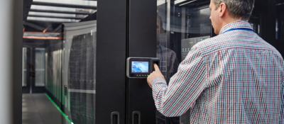 Man entering code on keypad at a room full of servers
