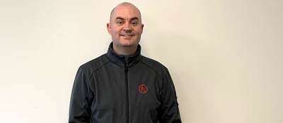 Seán Flannagan poses for EWeek picture. He's wearing a dark grey jacket with the red UL logo on its left pocket.