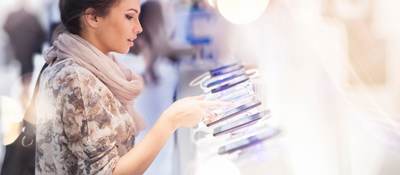 Consumer looking at several mobile devices in retail setting
