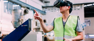 Manufacturing engineer wearing VR goggle headset in virtual reality simulation 