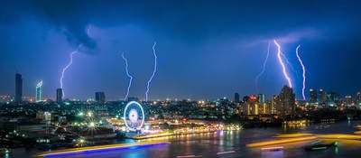 lightning striking cityscape at night 