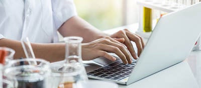 Person working on laptop at lab bench