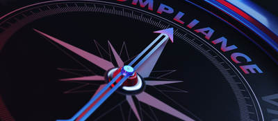 The arrow of a compass pointing toward the word compliance.