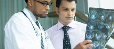 Two doctors examining a brain x-ray