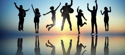 Group of people jumping in front of a sunset