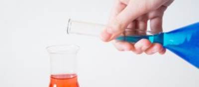 Blue vial being poured into orange vial.