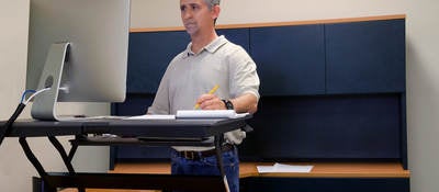 Man using stand up desk in office for good health