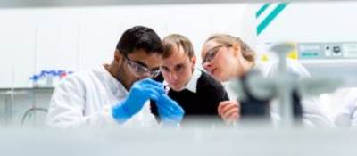 Scientists looking at vial