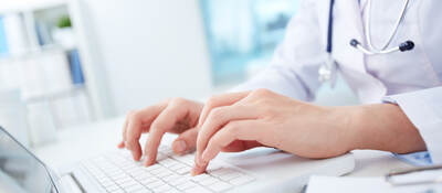 Doctor typing on a laptop