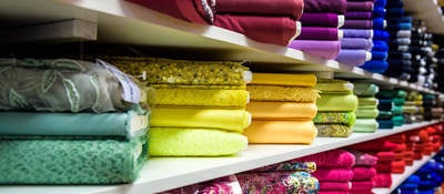 Colorful textiles folded on shelves 