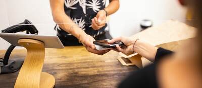 woman tapping a mobile phone to purchase