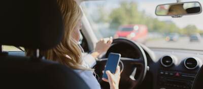 woman looking at a mobile phone in car