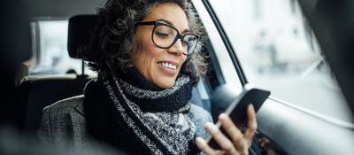 woman looking at a mobile phone in car