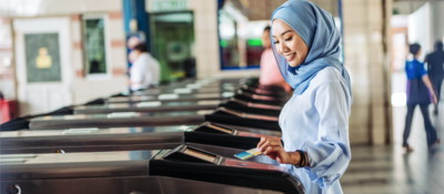 woman tapping a card on the ticket gate