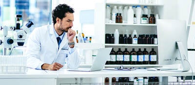 A doctor operates a computer in a laboratory setting.