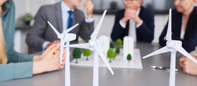Scale models of wind turbines on a desk during a planning meeting