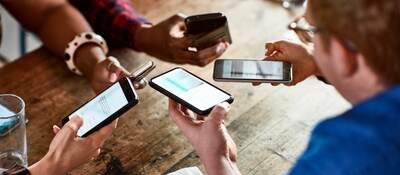 Friends sharing information on smartphones