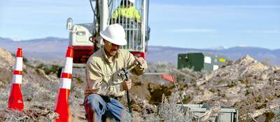 Worker installing cables for underground distribution.