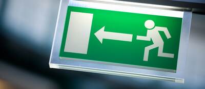 An illuminated emergency exit sign in a commercial office building.