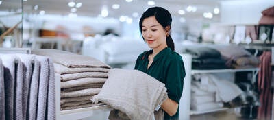 Asian woman shopping for bath towel