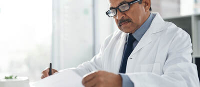 Doctor sitting at a desk doing paperwork