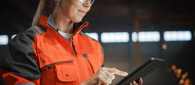 Engineer in PPE working on a tablet