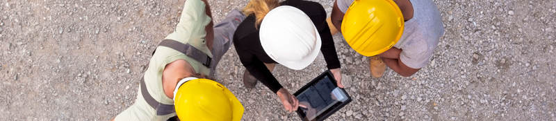 Workers on-site collaborating on a tablet