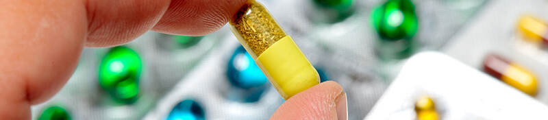 Close-up of hand holding a pill