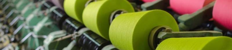 Textile industry - yarn spools on spinning machine in a textile factory
