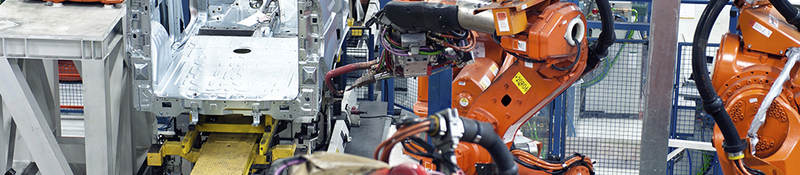 Vehicle factory manufacturing with robotic arms and automation.