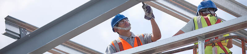A construction worker laboring on a steel structure