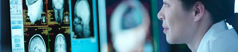 Woman in front of screen with medical scans  